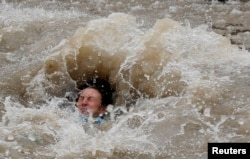 A participant in the Chicago Polar Plunge is engulfed by the partially frozen waters of Lake Michigan in Chicago, Illinois, March 1, 2015. REUTERS/Jim Young (UNITED STATES - Tags: SOCIETY ENVIRONMENT TPX IMAGES OF THE DAY) - RTR4RO1N