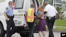 Police arrest a protester after she refused to leave the area during an attempt to shut down Interstate 70 near the St. Louis suburb of Ferguson, Missouri, where Michael Brown, an unarmed, black 18-year old was shot and killed by a white police officer on