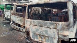 FILE - Burned buses are seen at the bus terminal in Buea, Cameroon, after gunfire broke out, July 9, 2018.