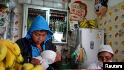 Seorang anak membersihkan mangkok di sebuah warung tempatnya bekerja di La Paz, Bolivia (Foto: dok). Kongres Bolivia, Rabu malam (3/7) menyetujui RUU yang memperbolehkan anak berusia 10 tahun untuk bekerja.