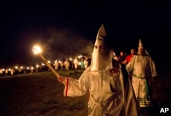 FILE - Members of the Ku Klux Klan participate in cross burnings in rural Paulding County near Cedar Town, Georgia, April 23, 2016.