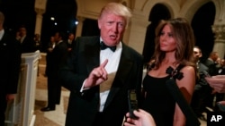 President-elect Donald Trump, with his wife, Melania, talks to reporters during a New Year's Eve party at Mar-a-Lago, Dec. 31, 2016, in Palm Beach, Fla. 