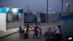 FILE - Syrian kids play outside their tents in the Kawergosk refugee camp in northern Iraq, April 8, 2017. 