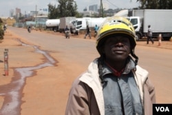 Boda boda driver Keneth Owuma shows off his new helmet, Kampala, Uganda, August 28, 2013. (Hilary Heuler for VOA)