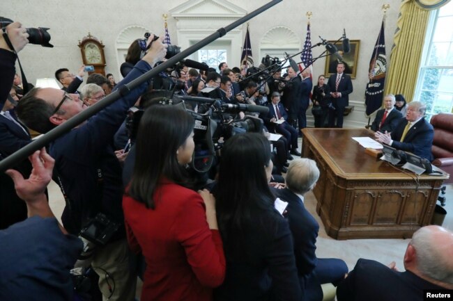 Surrounded by the press, President Donald Trump speaks while meeting with China's Vice Premier Liu He in the Oval Office of the White House in Washington, April 4, 2019.