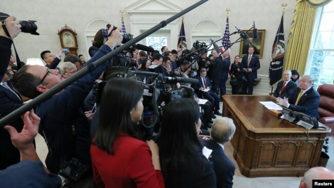 Surrounded by the press, President Donald Trump speaks while meeting with China's Vice Premier Liu He in the Oval Office of the White House in Washington, April 4, 2019.