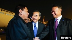 지난 10월 중국 베이징 공항에 도착한 로드리고 두테르테 필리핀 대통령(왼쪽)이 필리핀주재 중국대사와 만나 악수하고 있다.