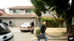 Oficiales de policía llevan bolsas de evidencia desde la casa de la familia del sospechoso en el tiroteo del Festival del Ajo de Gilroy, Santino William Legan, el lunes 29 de julio de 2019 en Gilroy, California.