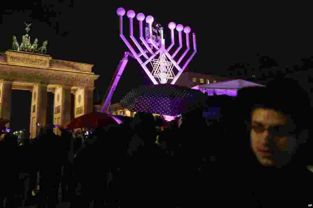 A giant Hanukkah Menorah set up by the Jewish Chabad Educational Center, is illuminated at the Pariser Platz in front of the Brandenburg Gate in Berlin, Tuesday, Dec. 12, 2017. (AP Photo/Markus Schreiber)