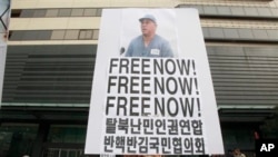 Protester holds portrait of American missionary Kenneth Bae during anti-North Korea rally in Seoul, South Korea, Feb. 16, 2014.