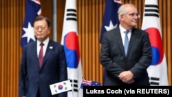 문재인(왼쪽) 한국 대통령과 스콧 모리슨 호주 총리가 13일 캔버라 시내 의사당에서 양국 주요 계약 서명식을 참관하고 있다.