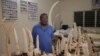 Ivory trafficker Emile N'Bouke stands amidst seized ivory carvings and elephant tusks while talking with journalists after his arrest, in Lome, Togo, Aug. 6, 2013.