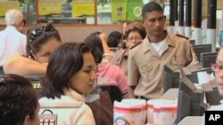 Shoppers stand in line to pay for groceries at a privately-owned supermarket in Venezuela