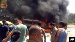 In this photo released by the Syrian official news agency SANA, Syrians gather at the site of a car bombing in the port city of Latakia, Syria, Sept. 2, 2015.