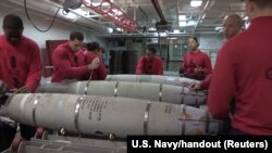 Arşîv: Hêzên Deryayî yên Amerîkayê di Firokhigira (USS George H.W. Bush) de, bombeyên ji curê GBU-54 500-pound amade dikin.