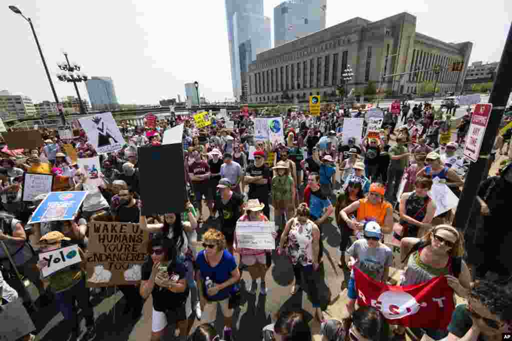 People pause during a demonstration and march on Market Street in Philadelphia, April 29, 2017. Thousands of people gathered across the country to march in protest of President Donald Trump&#39;s environmental policies, which have included rolling back restrictions on mining, oil drilling and greenhouse gas emissions at coal-fired power plants.
