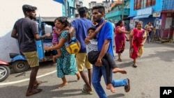 Warga Sri Lanka berlarian menyelamatkan diri setelah polisi menemukan bahan peledak di sebuah kendaraan yang terparkir dan kemudian meledak di Ibu Kota Kolombo, 22 April 2019. 