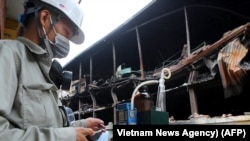 Nhân viên Sở Tài nguyên và Môi trường tiến hành quan trắc không khí tại địa điểm nhà kho bị cháy của công ty Rạng Đông, quận Thanh Xuân, Hà Nội, ngày 31 tháng 8, 2019.