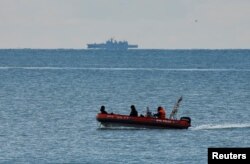 A boat of Russian Emergencies Ministry sails near the crash site of a Russian military Tu-154 plane, which crashed into the Black Sea on its way to Syria on Sunday. Forty-five ships and 135 divers from across Russia are involved in the search.