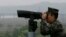 Военнослужащий морской пехоты Южной Кореи смотрит в бинокль в сторону Севера , Южная Корея, 16 мая 2018 года.