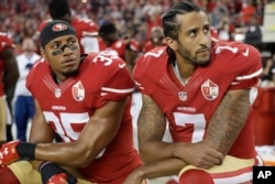 San Francisco 49ers safety Eric Reid (35) and quarterback Colin Kaepernick (7) kneel during the national anthem before an NFL football game against the Los Angeles Rams in Santa Clara, California, Sept. 12, 2016.