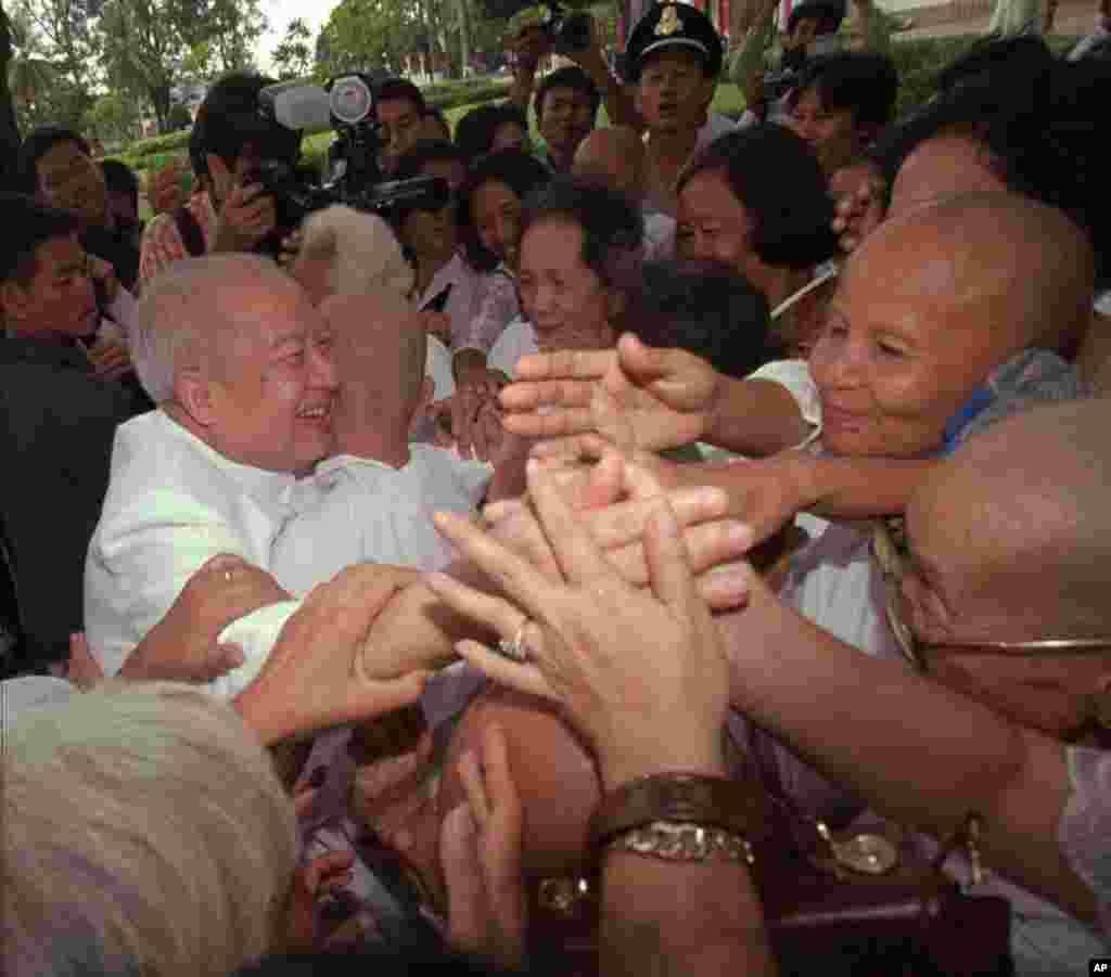 Cambodia's King Norodom Sihanouk is greeted by Buddhist nuns at a temple in Siem Reap on September 1, 1997. 