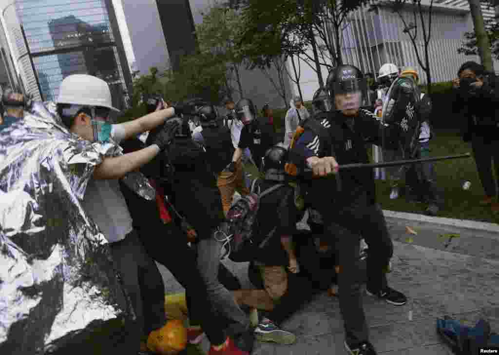 A riot policeman prevents pro-democracy protesters from getting near during clashes outside the government headquarters in Hong Kong, December 1, 2014.