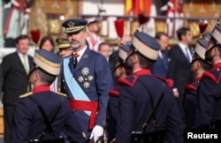 Spain's King Felipe reviews the guard during a military parade marking Spain's National Day in Madrid, Oct. 12, 2017.