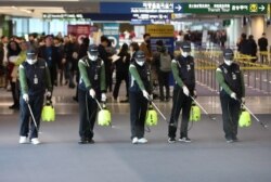 韩国仁川国际机场的工人为防范新型冠状病毒入侵在海关处喷洒消毒药水。（2020年1月21日）