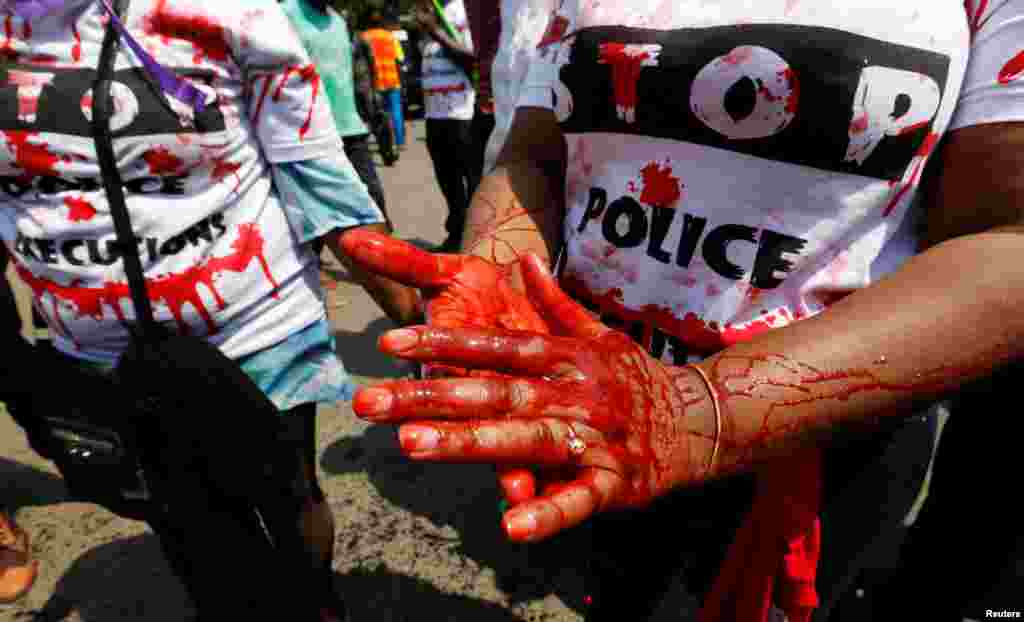 Un membre de la société civile a enduit ses mains de faux sang et chante des slogans lors de la manifestation contre les meurtres extrajudiciaires après le meurtre de Willie Kimani, avocat et défenseur des droits de l'homme, à Nairobi, Kenya le 4 juillet. Lire la suite ici. 