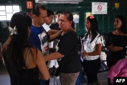 People bid farewell to relatives before boarding a bus at a station in Caracas, Venezuela, Jan. 3, 2019.