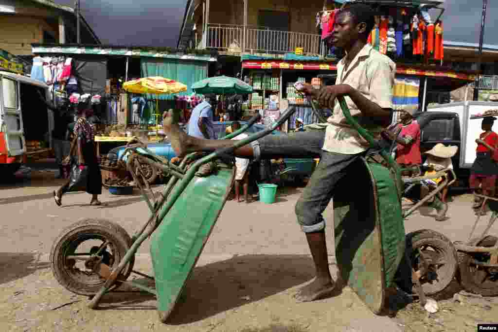 A labourer rests on wheelbarrows in the Abule Egba district of Lagos.