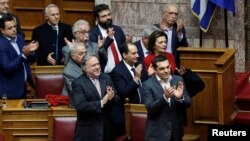 Greek Prime Minister Alexis Tsipras (R) and members of his government applaud after a vote on an accord between Greece and Macedonia changing the former Yugoslav republic's name, Athens, Greece, Jan. 25, 2019. 