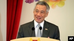 FILE - Singapore's Prime Minister Lee Hsien Loong delivers a speech during the launch of Commemorative Notes of the 50th Anniversary of the Currency Interchangeability Agreement between Singapore and Brunei at the Istana, July 5, 2017, in Singapore.