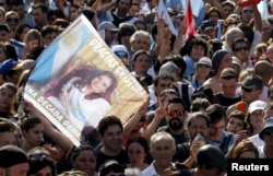 FILE - People wait for the speech of Argentina's President Cristina Fernandez while carrying a banner that reads "Gracias Cristina" during a rally in front of the Casa Rosada Presidential Palace in Buenos Aires, Argentina, Dec. 9, 2015.