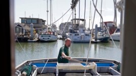 Salmon fisherman Mike Hudson works on the back of his boat at the Berkeley, Calif., Marina on Thursday, July 22, 2021. (AP Photo/Eric Risberg)