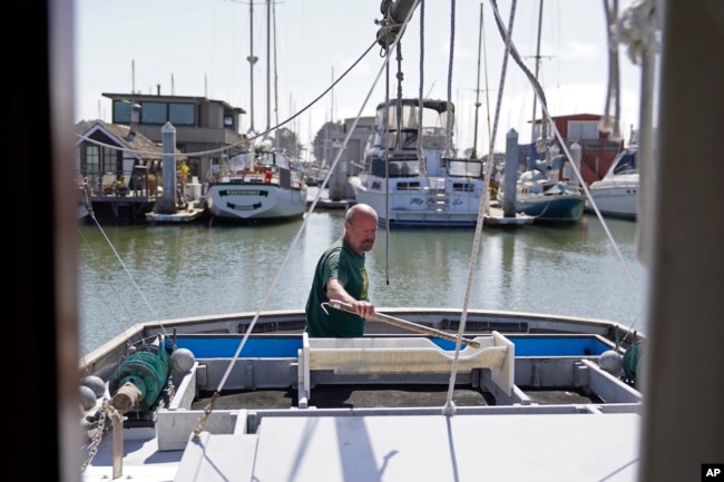 Salmon fisherman Mike Hudson works on the back of his boat at the Berkeley, Calif., Marina on Thursday, July 22, 2021. (AP Photo/Eric Risberg)