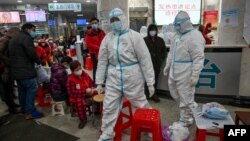 资料照：武汉红十字医院身穿防护服的医务人员和等候就诊的病患。（2020年1月25日）