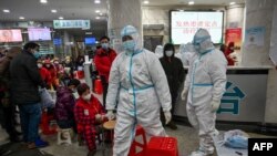 武汉红十字医院身穿防护服的医务人员和等候就诊的病患。（2020年1月25日）