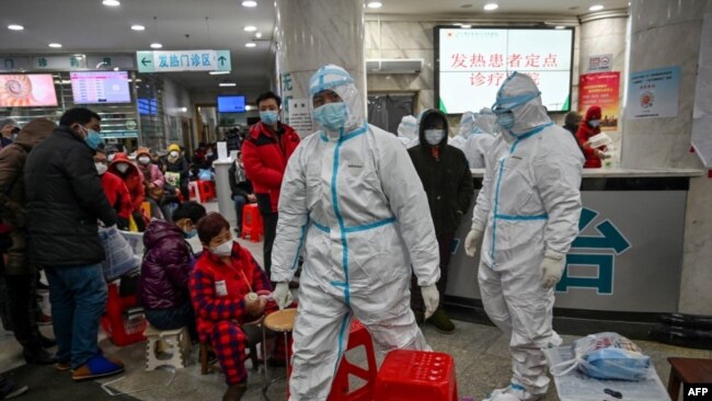 资料照：武汉红十字医院身穿防护服的医务人员和等候就诊的病患。（2020年1月25日）