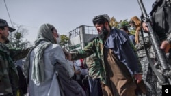 Des membres des talibans empêchent les femmes de manifester pour les droits des femmes à Kaboul, en Afghanistan, le 21 octobre 2021. Les talibans ont violemment réprimé la couverture médiatique de la manifestation. (Photo AFP/ Bulent Kilic)