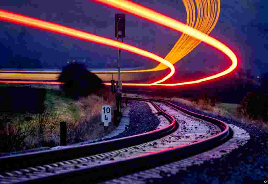 A long exposure photo shows a regional train approaching the station of Wehrheim near Frankfurt, Germany.