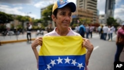 Una mujer sostiene una bandera venezolana durante una manifestación contra el gobierno de Nicolás Maduro, en Caracas, el 30 de enero de 2019. 