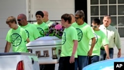 Pallbearers wearing anti-bullying t-shirts carry the casket of 12-year-old Rebecca Sedwick. Authorities believe she killed herself after being bullied. (2013)