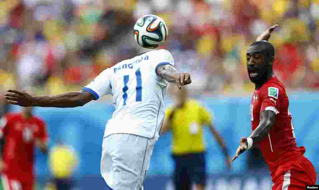 Swiss Johan Djourou, right, fights for the ball with Honduran Jerry Bengtson, at the Amazonia arena in Manaus, June 25, 2014. 