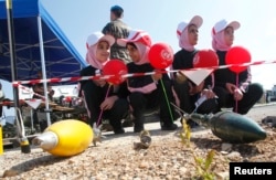 FILE - Schoolchildren attend an awareness campaign teaching them to identify mines and unexploded cluster bombs at the United Nations Interim Force in Lebanon (UNIFIL) headquarters in the town of Naqoura in southern Lebanon, April 4, 2014.