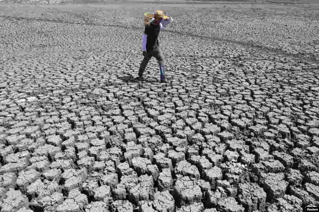A man walks on cracked ground at the Las Canoas dam, some 59 km (37 miles) north of the capital Managua, Nicaragua, Apr. 26, 2013.
