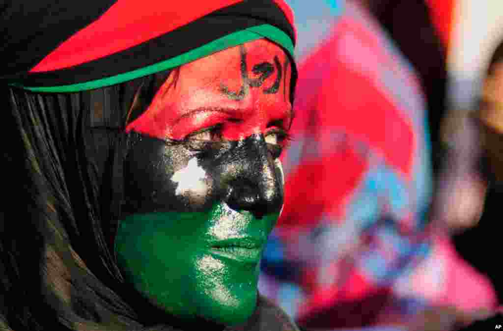 June 29: A woman with her face painted in the colours of the Kingdom of Libya flag attends a protest against Muammar Gaddafi near the court house in Benghazi. The word on her forehead reads, "Leave". (Reuters/Esam Al-Fetori)