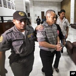 Pedro Pimentel is escorted out of the Supreme Court in Guatemala City, March 12, 2012.