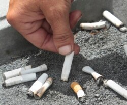 FILE - A smoker snuffs out a cigarette at the Capitol in Sacramento, Calif., June 22, 2012.